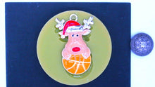 Load image into Gallery viewer, Silicone Mold Christmas Reindeer with Santa Hat and antlers holding a basketball pin jewelry wax, gypsum, resin, hot glue, soap, clay, metal
