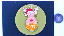 Load image into Gallery viewer, Silicone Mold Christmas Reindeer with Santa Hat and antlers holding a basketball pin jewelry wax, gypsum, resin, hot glue, soap, clay, metal
